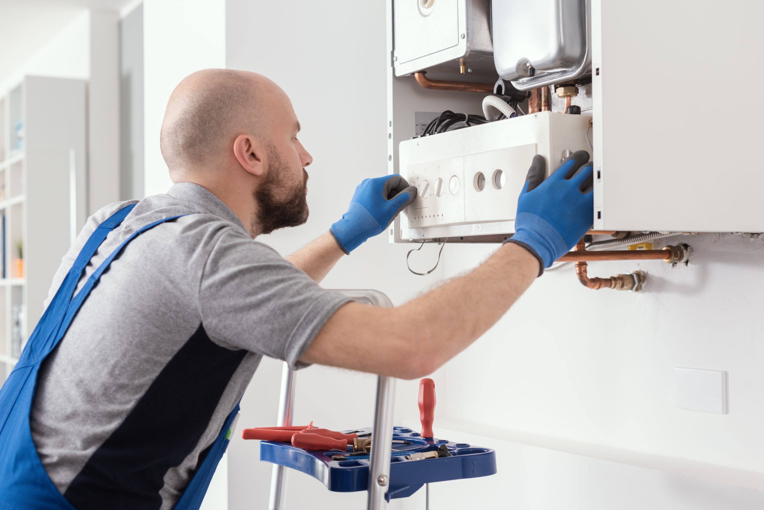 Professional engineer servicing a boiler at home