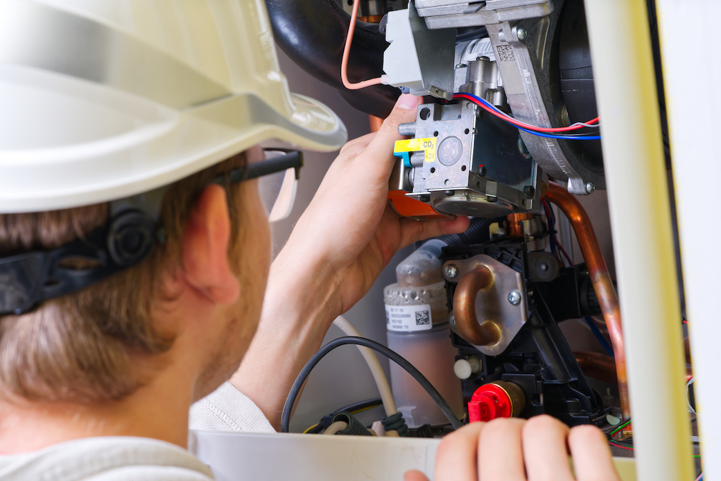 Technician servicing or Repair of a gas boiler, setting up and servicing. gas boiler for heating