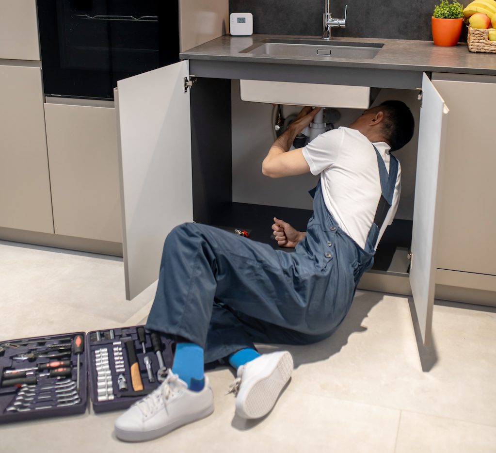 Man reclining looking under kitchen sink